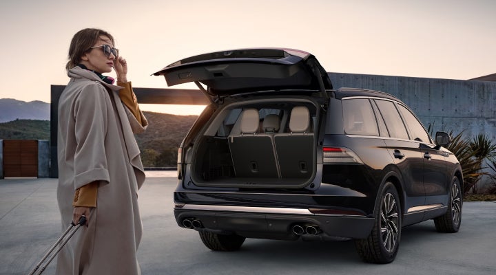 A woman approaches a 2026 Lincoln Aviator® SUV with its rear liftgate open. | Koons Lincoln of Bethesda in Silver Spring MD