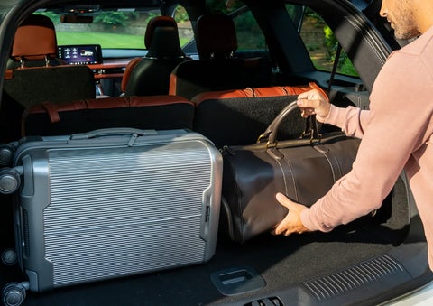 A man loads luggage into the rear of a 2026 Lincoln Aviator® SUV through the opened rear liftgate. | Koons Lincoln of Bethesda in Silver Spring MD