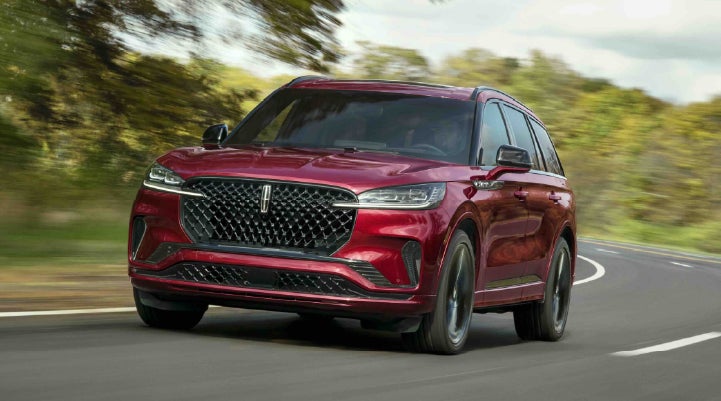 A 2027 Lincoln Aviator® SUV is being driven on a country road | Koons Lincoln of Bethesda in Silver Spring MD