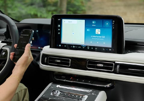 A person pairs thier phone with the center touchscreen of a 2027 Lincoln Aviator® Black Label™ SUV | Koons Lincoln of Bethesda in Silver Spring MD
